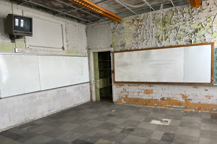 A classroom inside the Brainerd Junior High classroom building with whiteboards and peeling paint, awaiting restoration